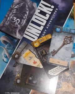 The box of the escape room board game Unlock, showing illustrated clue cards with a picture of a key
