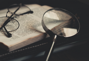 a magnifying glass and a pair of spectacles resting on top of a book