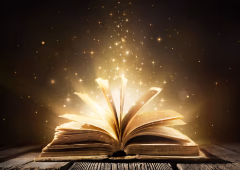 a story book lying open on its spine with golden light coming out of it