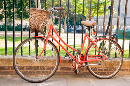 a bicycle chained to a railing outdoors in cambridge