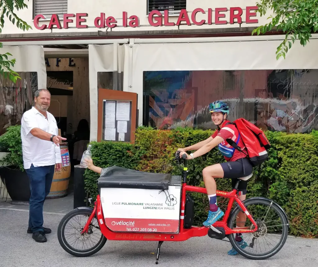 Photo de la livraison d'une carafe de l'Eau de Sion à un restaurateur de SIon