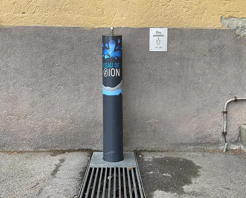 Photo d'une fontaine à eau dans une cour d'école de Sion