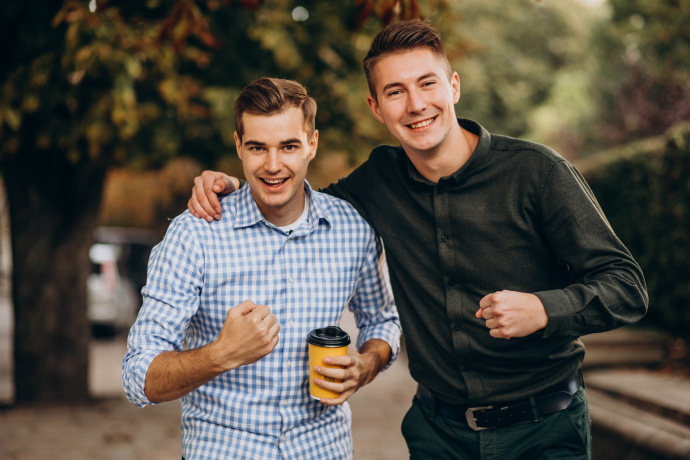 two men standing outside smiling