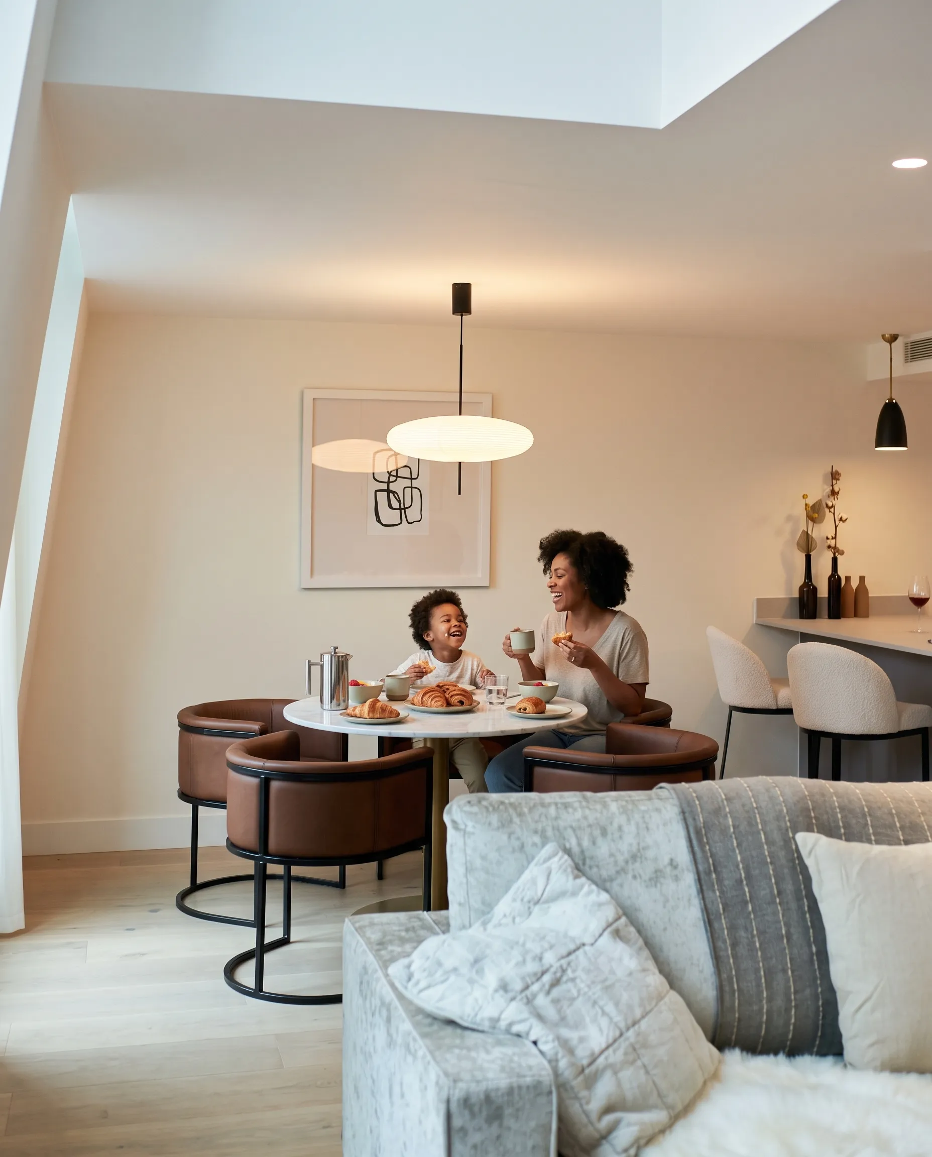 Parent and child enjoying breakfast together in a LEVEN apartment lounge