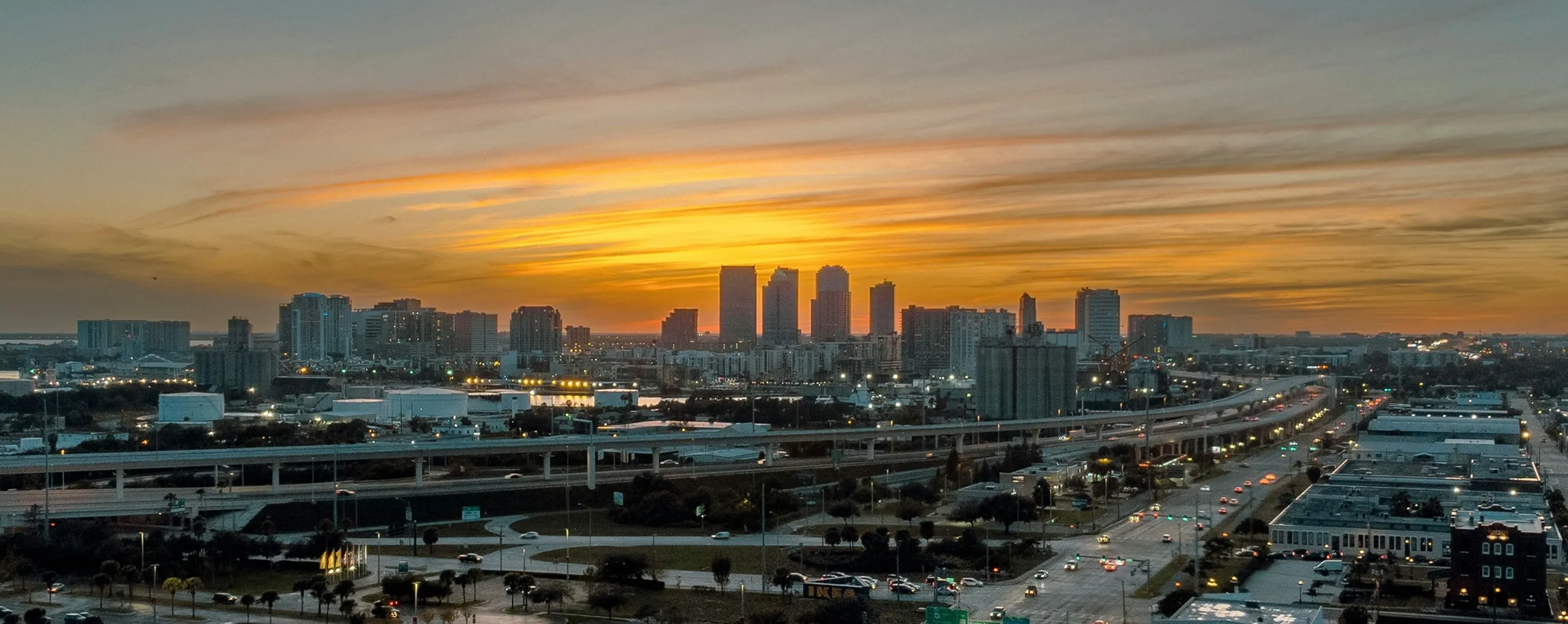 City skyline at sunset with highway and glowing sky