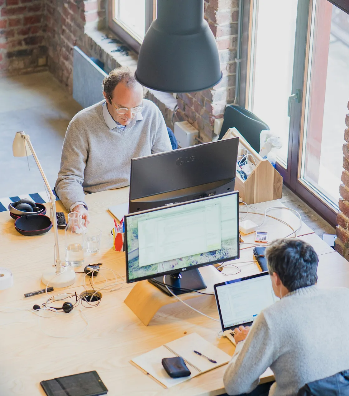 Two people working at desks with computers in an office