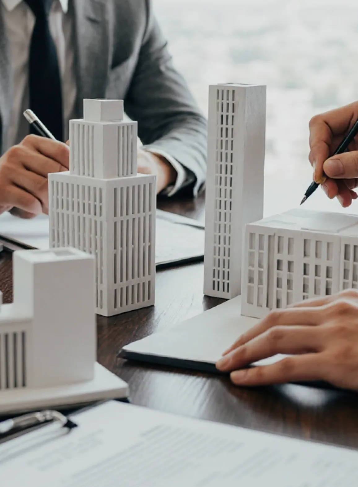 People reviewing small architectural building models