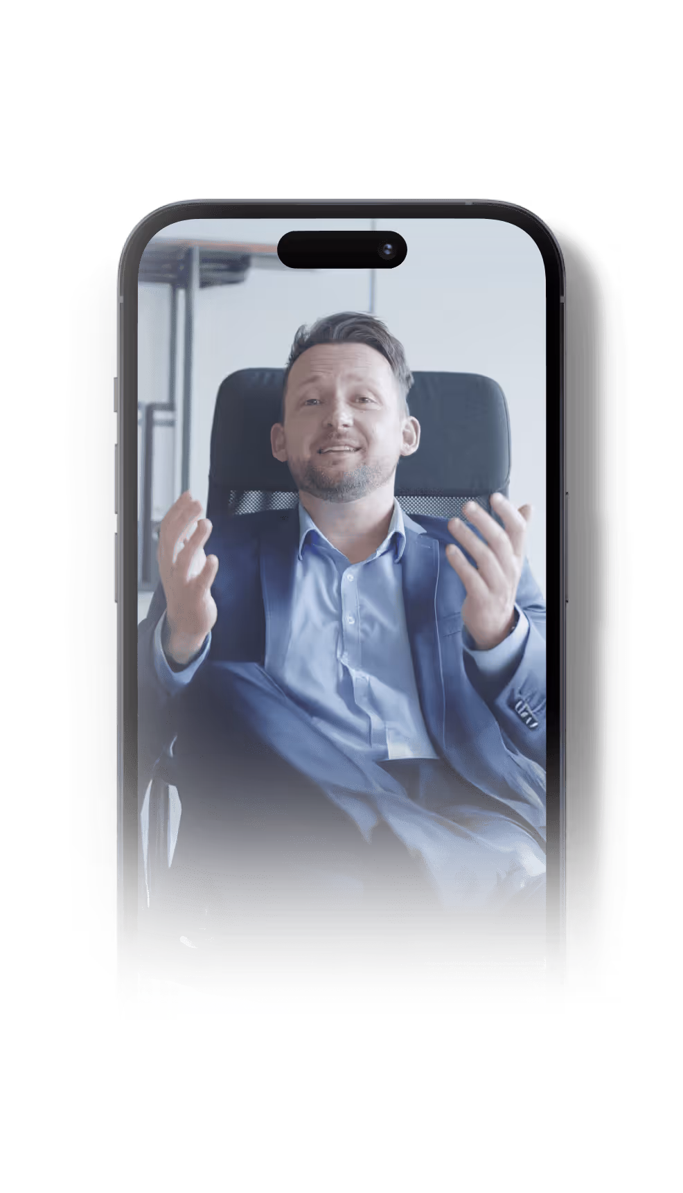 Mann in Business-Anzug sitzt entspannt auf Bürostuhl und gestikuliert während eines Videoanrufs auf einem Smartphone.