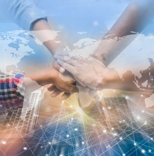 Diverse hands joined together over world map, representing global teamwork and connection