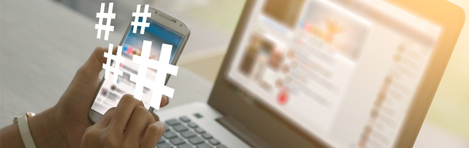 Hashtag symbols floating over smartphone and laptop, representing social media