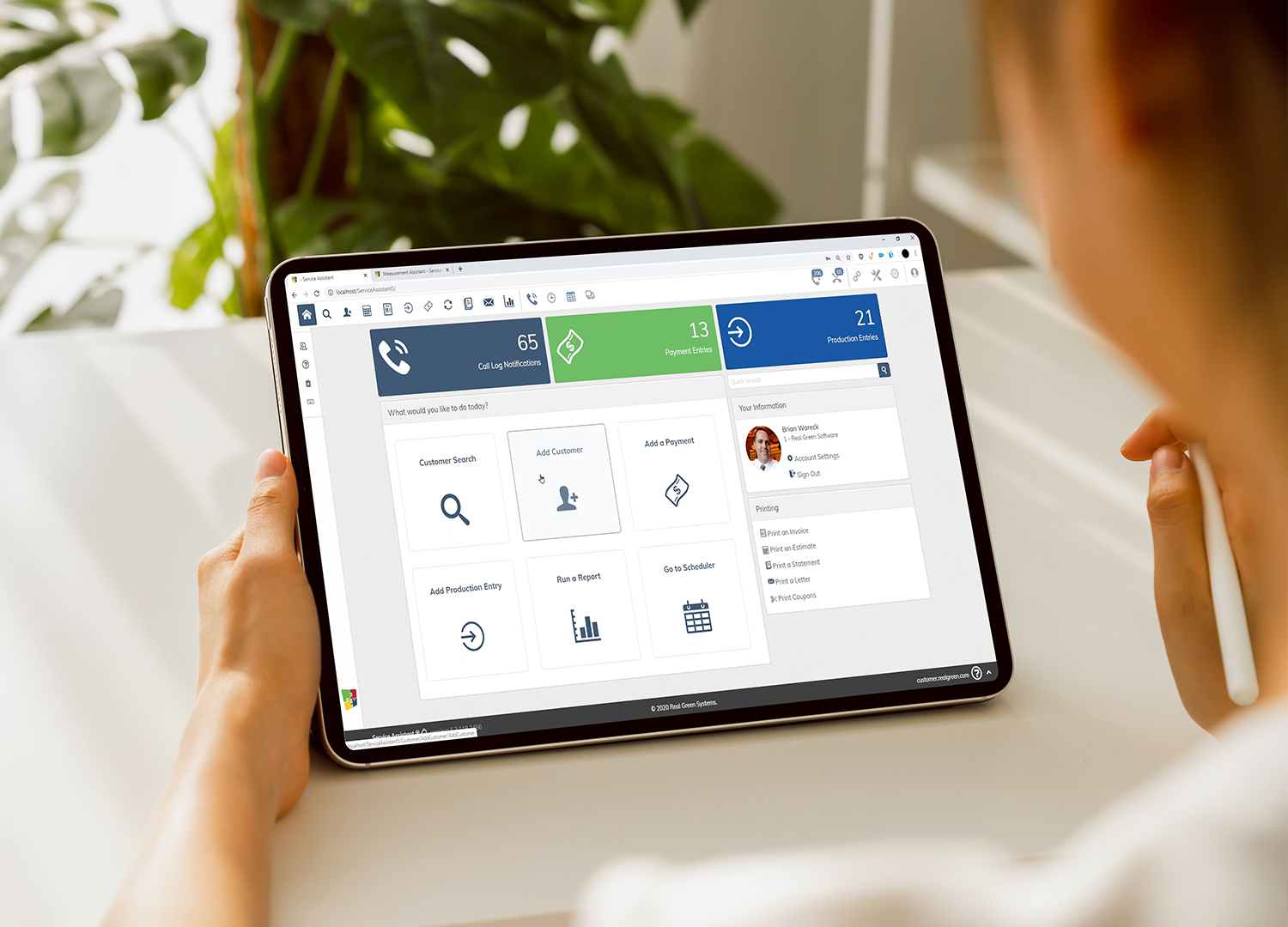 Business dashboard on tablet with navigation menu and green plants