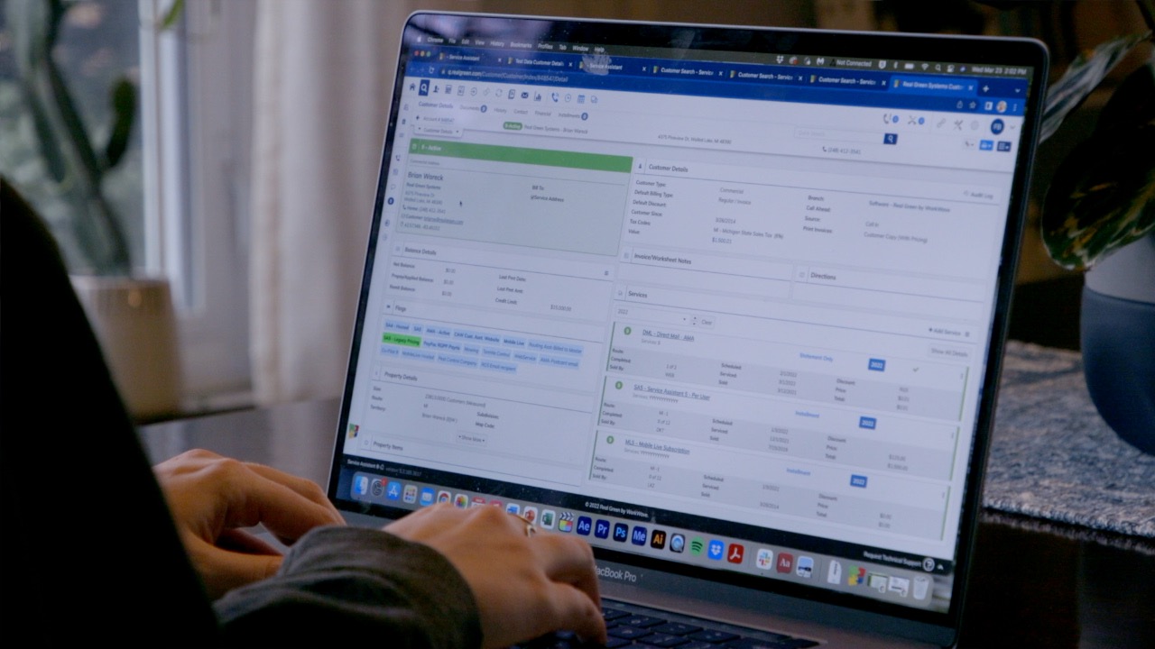 Person working on customer details in business software on MacBook