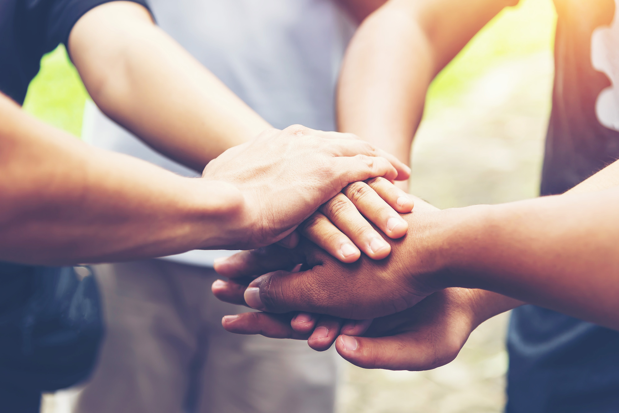 Diverse hands joined together in a symbol of unity and teamwork