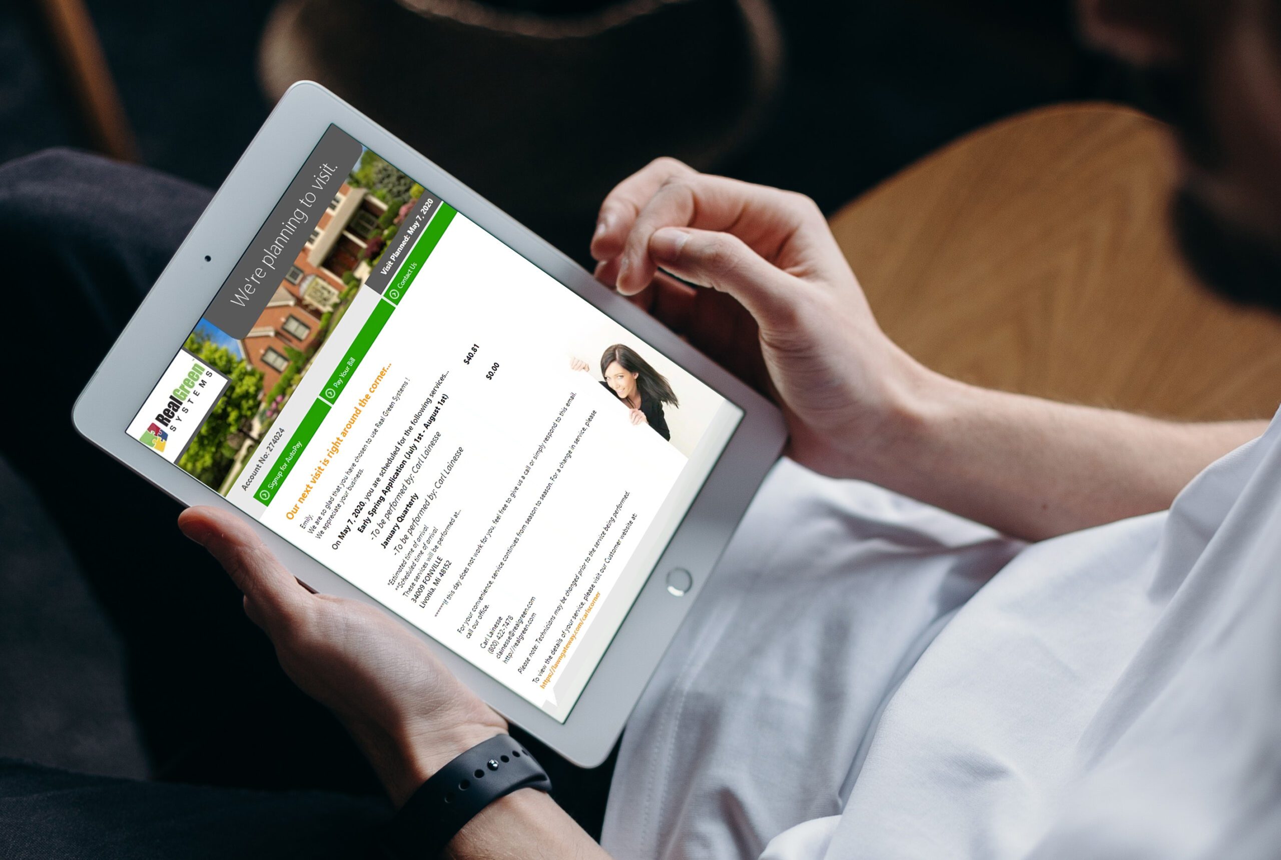 Person browsing real estate website on tablet while wearing smartwatch
