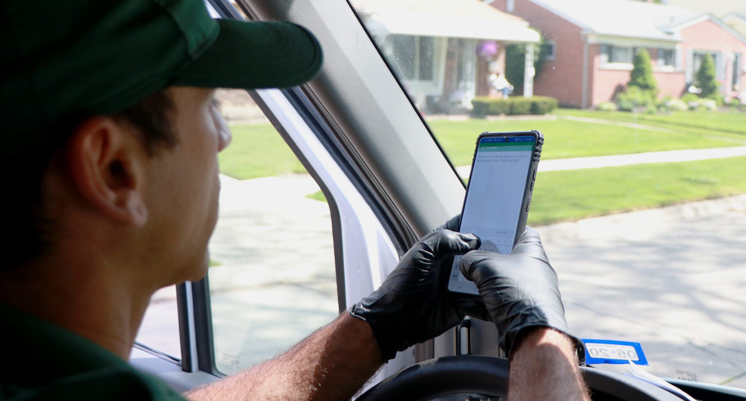 Driver using smartphone while sitting in car, gloved hand on screen