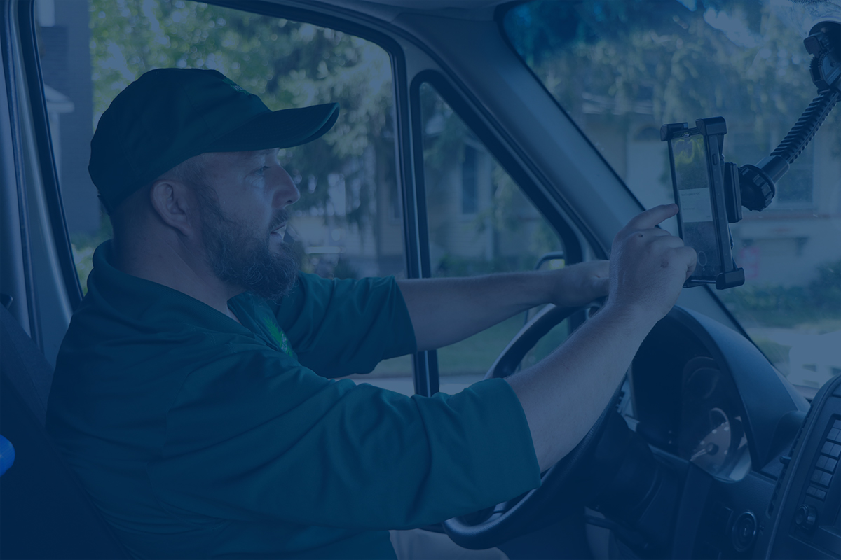Driver using smartphone mounted on dashboard while steering vehicle