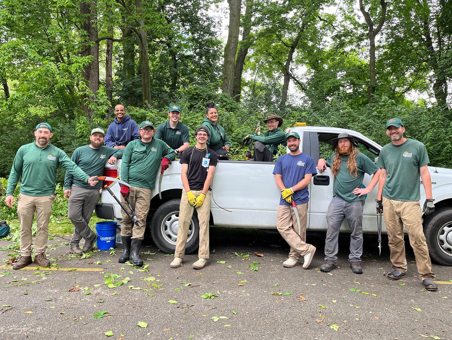 Park maintenance team poses with work truck in forest setting