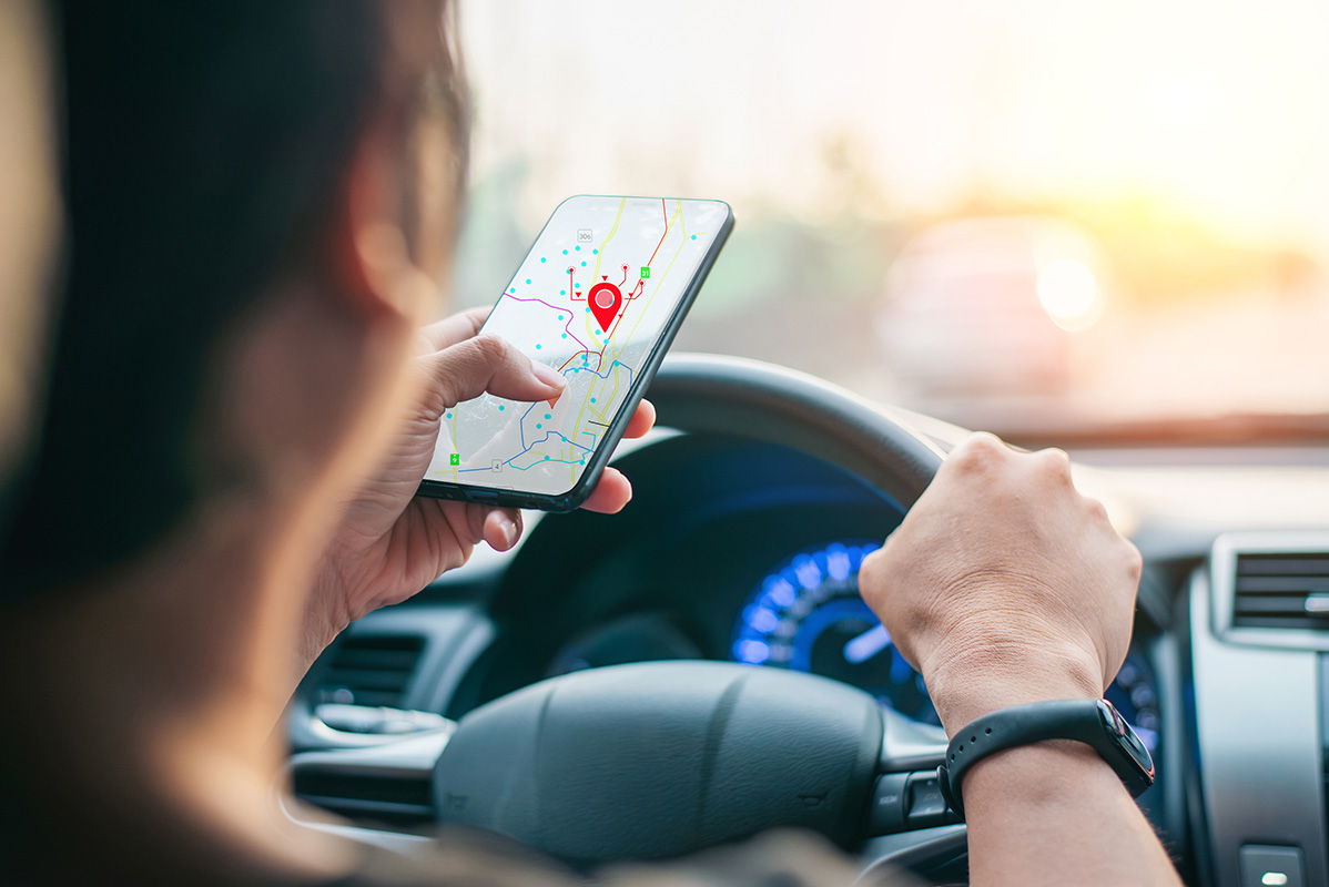 Driver using GPS navigation app on smartphone while driving