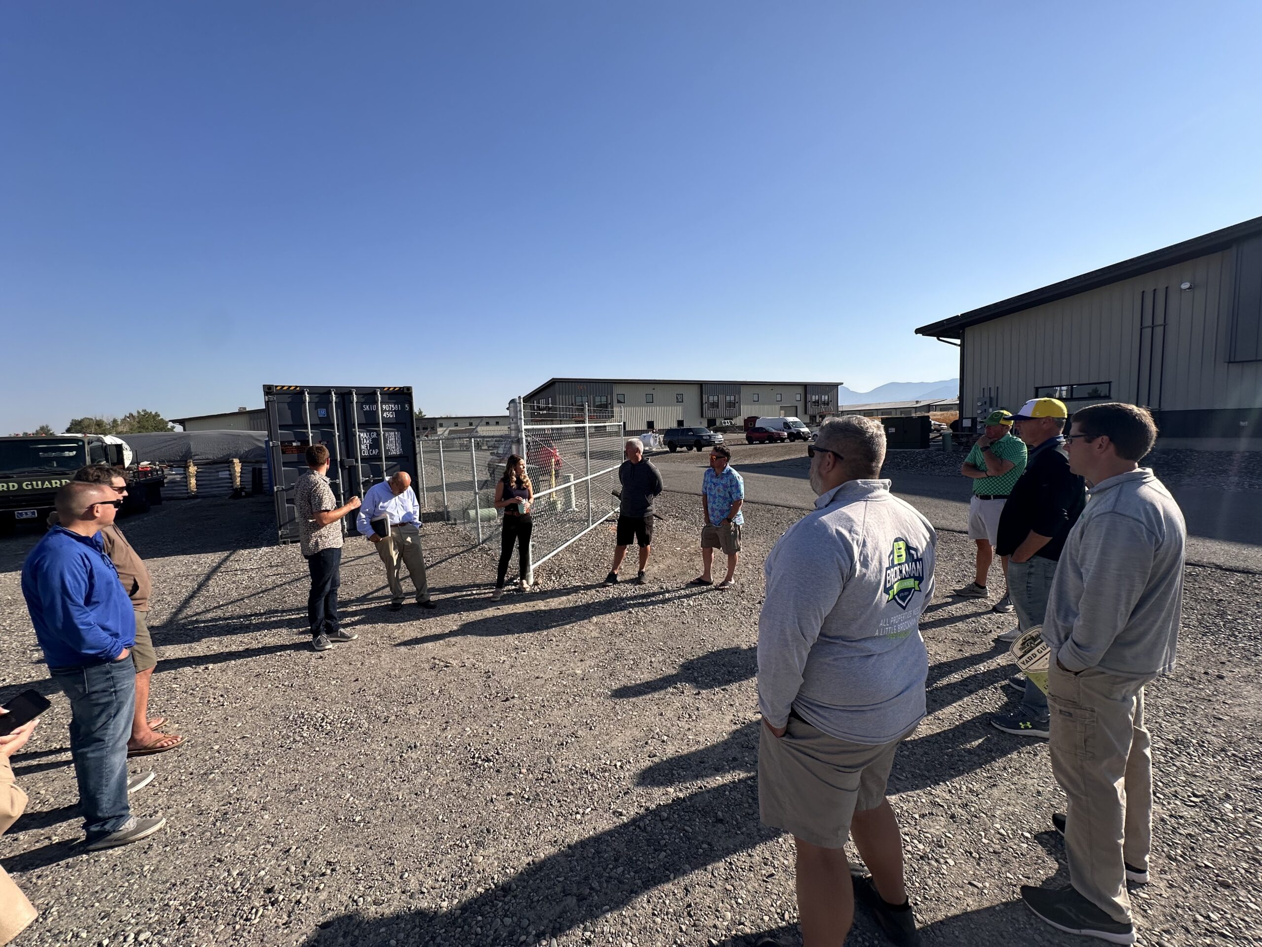 Group of workers in safety gear discussing project at industrial outdoor site