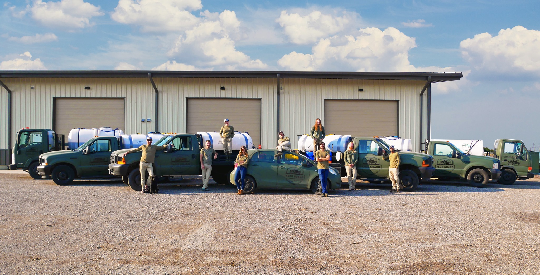 Team with water trucks in front of warehouse on cloudy day