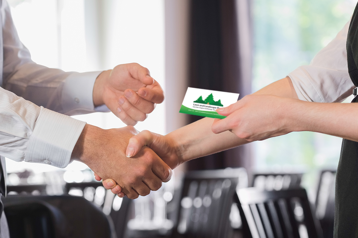 Business handshake and exchanging green landscape business card