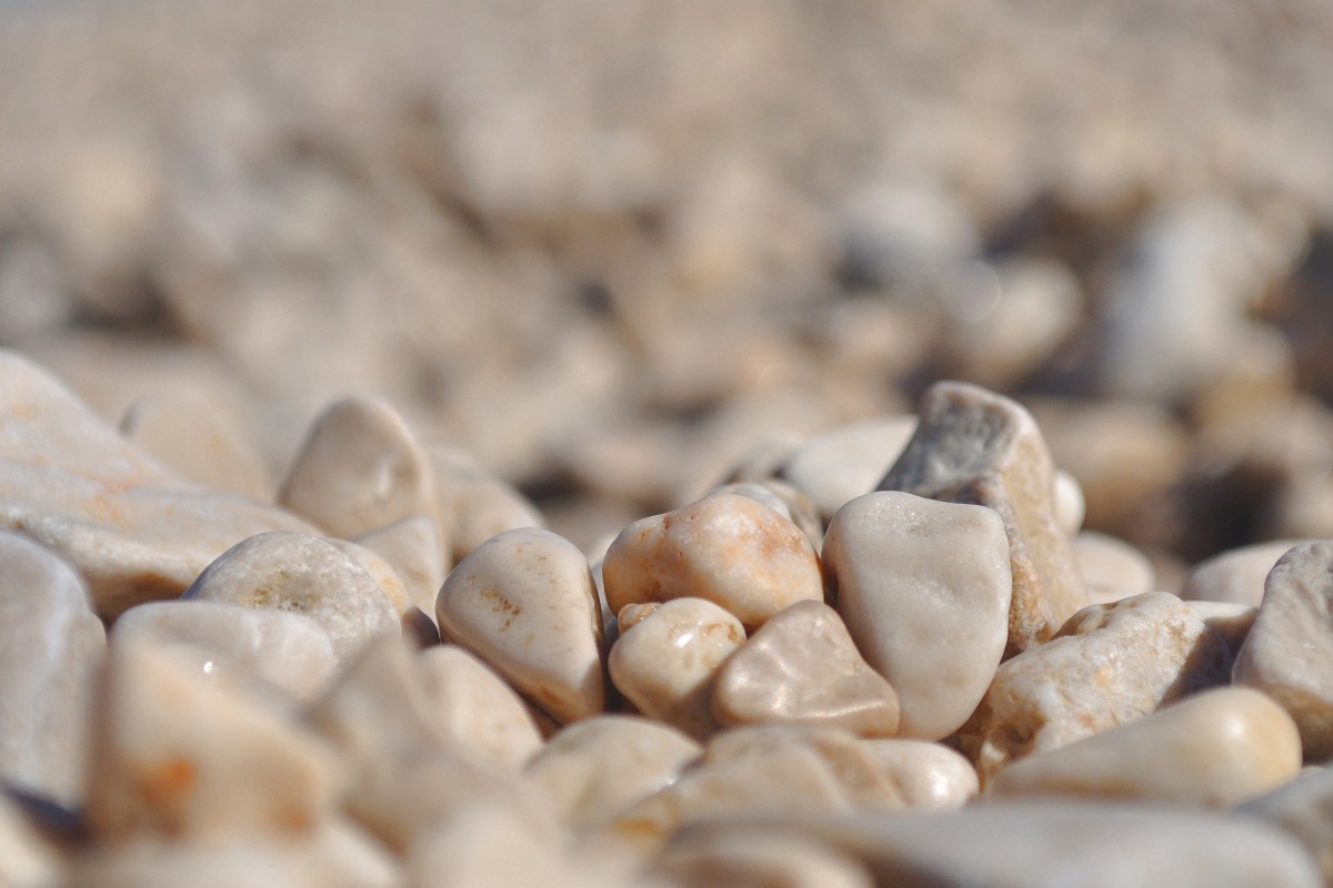 Close-up of smooth, rounded pebbles in neutral beige and white tones