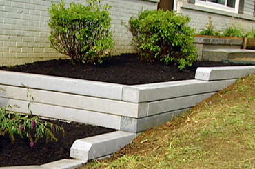 Landscaped garden with white stone retaining wall and green shrubs