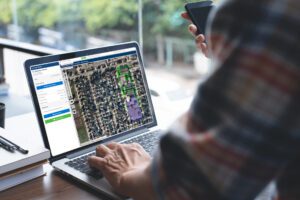 Person analyzing aerial map or satellite imagery on laptop screen