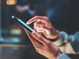 Person scrolling on smartphone with blurred background