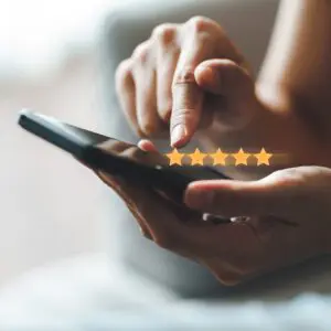 Hand giving five-star rating on smartphone touchscreen
