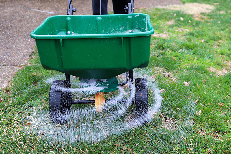 Green lawn spreader dispersing water in circular motion on grass