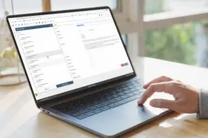 Laptop screen displaying a web form or dashboard with user's hand typing