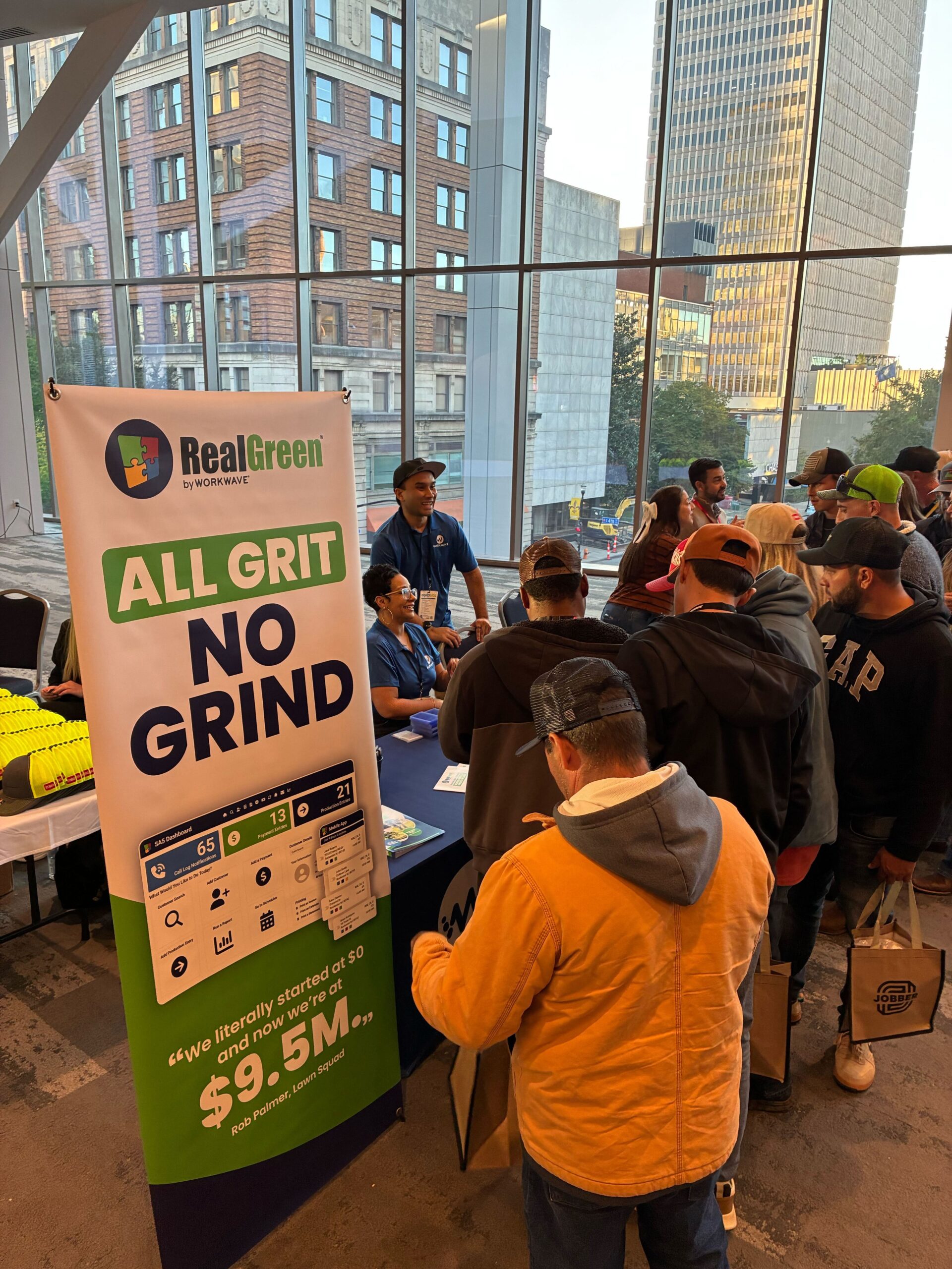 RealGreen conference with "All Grit No Grind" banner and attendees