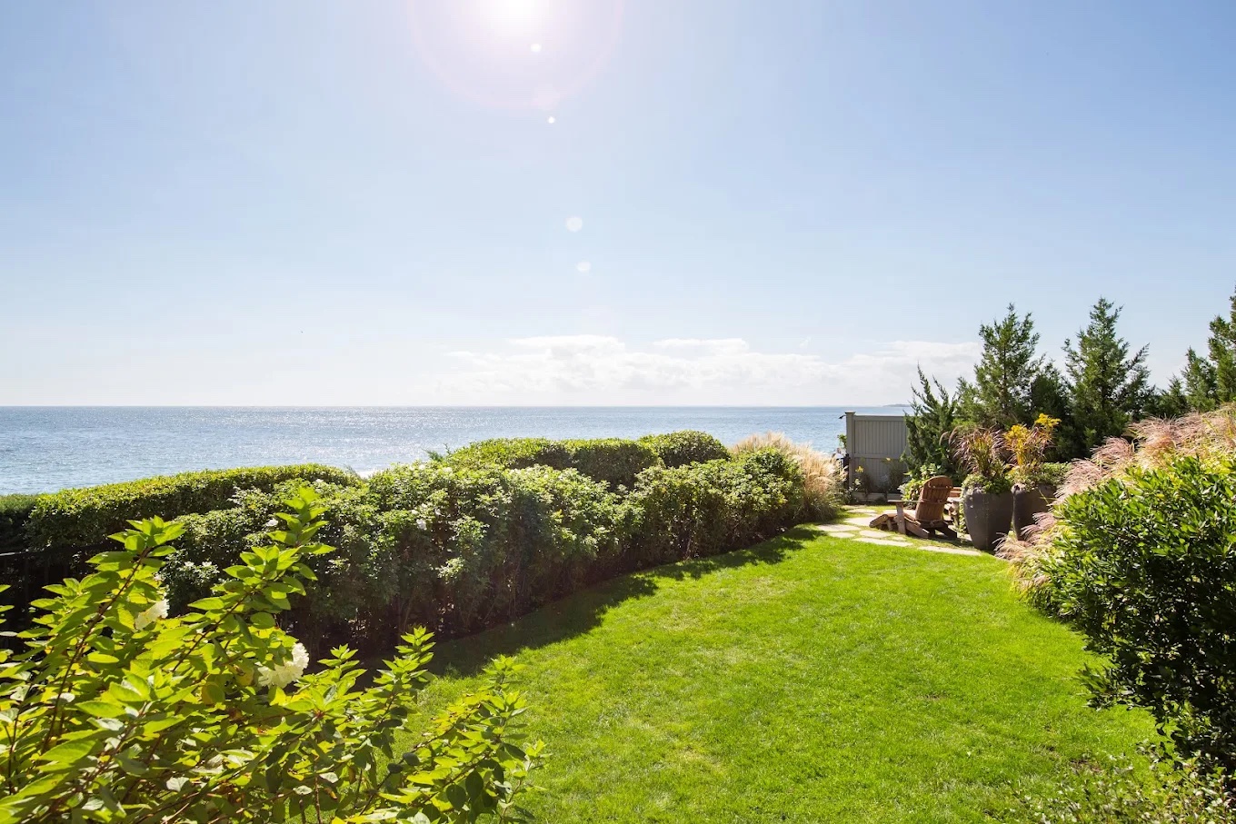 Lush green lawn with ocean view, hedges, and coastal landscaping