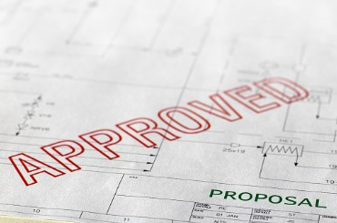 Approved stamp on proposal document with technical blueprint background