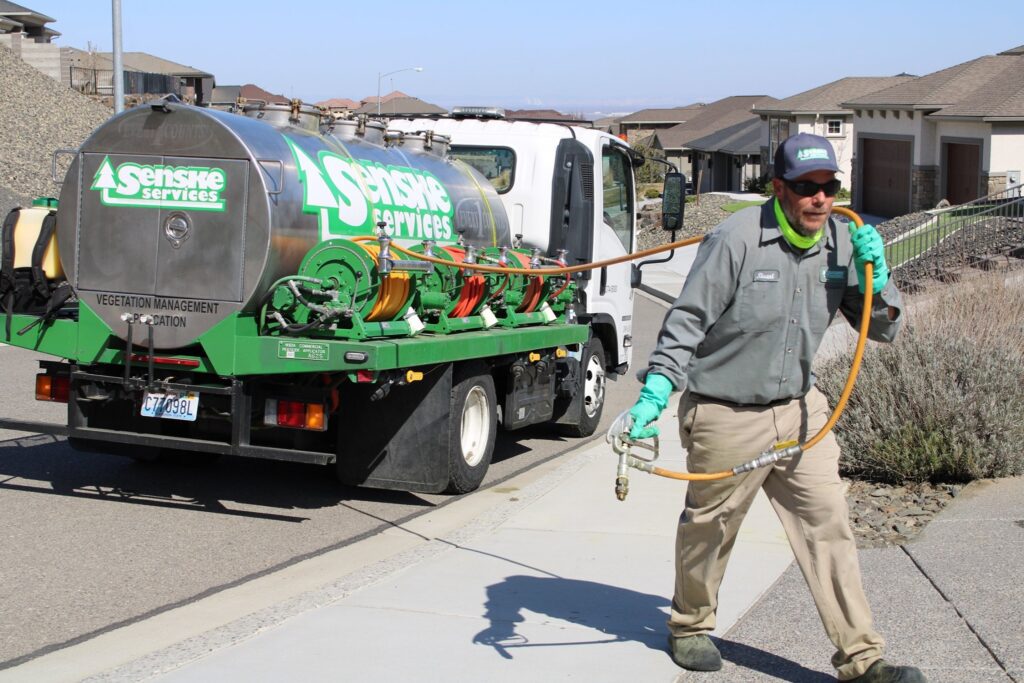 Sensire Services truck with worker spraying vegetation management solution