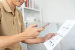 Person in beige shirt reviewing document, pointing at important detail