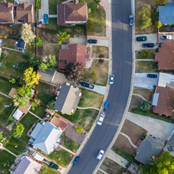 Aerial view of suburban neighborhood with houses, yards, and curved street