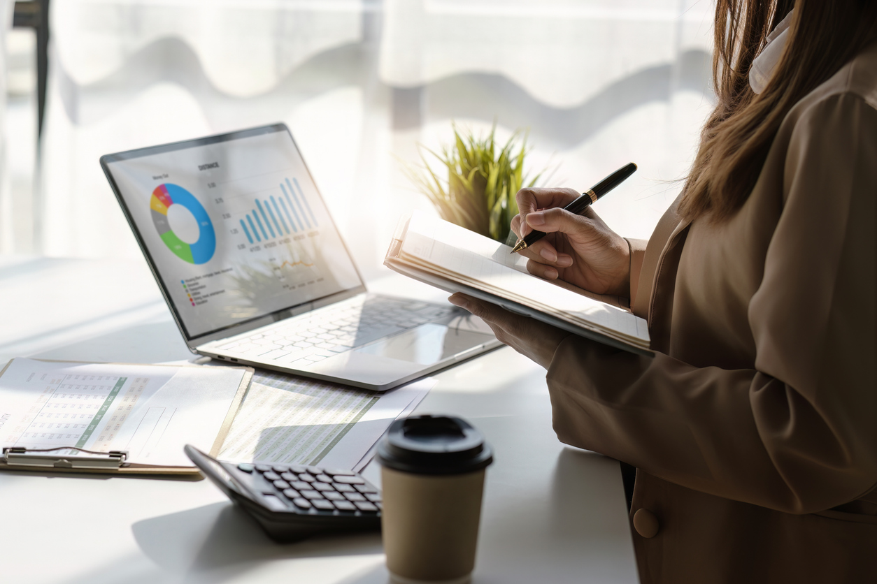 Business analyst reviewing financial charts and data on laptop