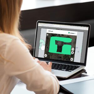 Person working on laptop with green graphic design software open