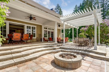 Luxurious outdoor patio with pergola, fire pit, and comfortable seating area