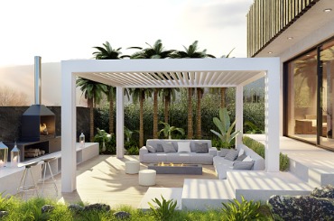 Modern outdoor patio with white pergola, seating, and lush tropical plants