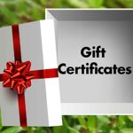 White gift certificate with red bow on green blurred background