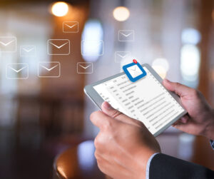 Person using smartphone with digital email icons and blurred background