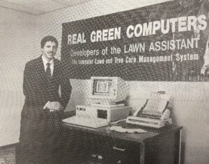Vintage computer advertisement with salesman standing next to Real Green Computers display