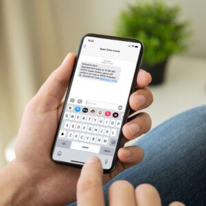 Hand holding smartphone with text message open on screen