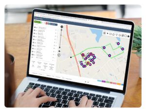 Laptop screen displaying digital map with location pins and navigation interface
