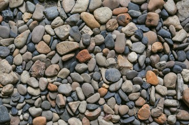 Smooth river rocks in various shades of gray, brown, and orange