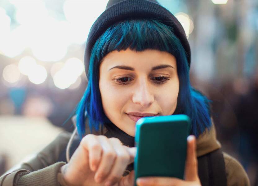 woman with blue hair on her mobile phone