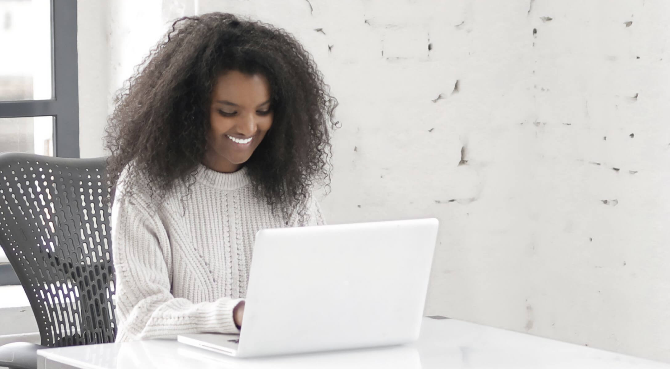 Woman with curly hair on a laptop